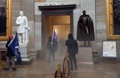 Supporters of President Donald Trump enter the US Capitol Rotunda as irritating smoke fills a corridor on January 6, 2021. (Photo by SAUL LOEB/AFP via Getty Images)