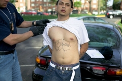 Armed police from Maryland's Prince George's County Anti-Gang Unit question and detain a confirmed gang member of Mara Salvatrucha 13, or MS-13, April 20, 2006 in Langley Park, Maryland. (Photo by Robert Nickelsberg/Getty Images)