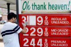 An employee of a gas station adjusts gasoline pump prices as they continue to fall with the oil market in turmoil on April 21, 2020, in Arlington, Virginia. (Photo by OLIVIER DOULIERY/AFP via Getty Images)