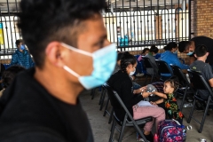 A migrant girl from Central America waits with her mother for a bus after they are dropped off by the US Customs and Border Protection at a bus station near the Gateway International Bridge, between the cities of Brownsville, Texas, and Matamoros, Mexico, on March 15, 2021 in Brownsville, Texas. (Photo by CHANDAN KHANNA/AFP via Getty Images)