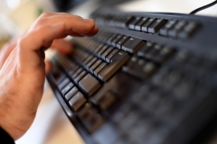 A man types on a keyboard. (Photo credit: KIRILL KUDRYAVTSEV/AFP via Getty Images)
