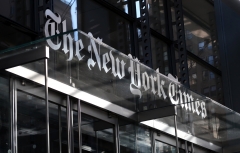 The corporate logo of the New York Times hangs above the front door of their headquarters on Oct. 23, 2018 in New York City. (Photo credit: Gary Hershorn/Getty Images)