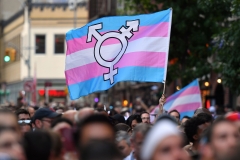 A transgender flag is brandished at a rally. (Photo credit: ANGELA WEISS/AFP via Getty Images)