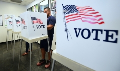 Featured is a line of voting booths. (Photo credit: FREDERIC J. BROWN/AFP via Getty Images)