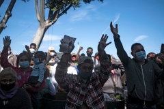 Migrants pray at camp where they wait for US authorities to allow them to start their asylum process outside El Chaparral crossing port in Tijuana, Baja California state, Mexico on March 17, 2021. (Photo by GUILLERMO ARIAS/AFP via Getty Images)