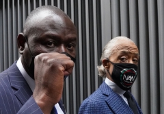 Attorney Benjamin Crump (L) holds up his fist as he walks with Reverend Al Sharpton after holding a press conference during the National Action Network(NAN) Virtual Convention 2021 in New York on April 14, 2021. (Photo by TIMOTHY A. CLARY/AFP via Getty Images)