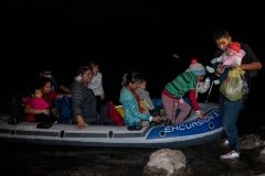 Guided by coyotes piloting an inflatable raft, migrants cross the Rio Grande River and arrive on American soil on April 23, 2021 in Roma, Texas. After crossing onto the shallow banks, the migrants hike half a mile through sandy gullies and shrub covered land towards waiting Border Patrol officers for processing and detention. (Photo by Benjamin Lowy/Getty Images)