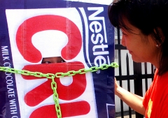 A protester from the environmental group Greenpeace looks out at a colleague from a Nestle 'Crunch' bar outfit to protest the alleged use of genetically modified (GM) ingredients in the popular chocolate bar and other Nestle products. (Photo credit: PETER PARKS/AFP via Getty Images)