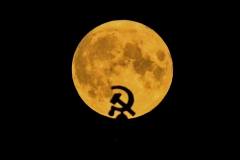 A sickle and hammer is seen against the moon. (Photo credit: KIRILL KUDRYAVTSEV/AFP via Getty Images)
