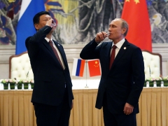 Russian President Vladimir Putin and Chinese President Xi Jinping toast with vodka during a signing ceremony on May 21, 2014. (Photo credit: Sasha Mordovets/Getty Images)
