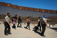 Migrants from Guatemala are escorted by US Border Patrol agents after they turned themselves over to authorities at the US-Mexico border May 12, 2021 in Yuma, Arizona. (Photo by RINGO CHIU/AFP via Getty Images)