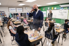 President Joe Biden points to his hair after a student told him she wanted to be a hairstylist when she grows up. (Photo credit: MANDEL NGAN/AFP via Getty Images)