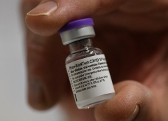 A medical worker holds a vial of the Pfizer-BioNTech COVID-19 vaccine. (Photo by Thomas Kienzle/AFP via Getty Images)