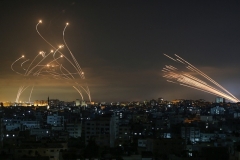 A barrage of rockets fired towards Israel from Gaza early on Friday, right, confronted by Israel's Iron Dome aerial defence system. (Photo by Anas Baba/AFP via Getty Images)