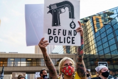 A Protester hold a sign reading "Defund the Police" outside Hennepin County Government Plaza during a demonstration against police brutality and racism on August 24, 2020 in Minneapolis, Minnesota. - It was the second day of demonstrations in Kenosha after video circulated Sunday showing the shooting of Jacob Blake -- multiple times, in the back, as he tried to get in his car, with his three children watching. (Photo by KEREM YUCEL/AFP via Getty Images)