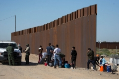 Migrants from Columbia wait to be processed after turning themselves over to authorities at the United States and Mexico border May 12, 2021 in Yuma, Arizona. (Photo by RINGO CHIU/AFP via Getty Images)