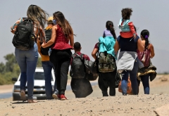 Migrants attempting to cross in to the U.S. from Mexico are detained by U.S. Customs and Border Protection at the border May 21, 2021 in San Luis, Arizona. (Photo by Nick Ut/Getty Images)