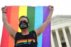 A man waves a rainbow flag in front of the U.S. Supreme Court. (Photo credit: JIM WATSON/AFP via Getty Images)