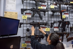 Employee Gorety Mejia takes down a HK MP5 for a customer at Full Armor Firearms store in Houston, Tex. (Photo credit: MARK FELIX/AFP via Getty Images)