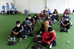 Young migrants wait to be tested for COVID-19 at the main detention center for unaccompanied children in the Rio Grande Valley in Donna, Texas on March 30, 2021. (Photo by DARIO LOPEZ-MILLS/POOL/AFP via Getty Images)