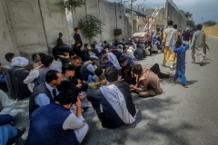 Afghan people sit outside the French embassy in Kabul on Aug. 17, 2021 waiting to leave Afghanistan. (Photo credit: ZAKERIA HASHIMI/AFP via Getty Images)