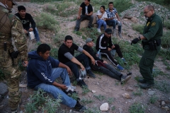 A U.S. Border Patrol agent processes a group of migrants in Sunland Park, New Mexico on July 22, 2021. (Photo credit: PAUL RATJE/AFP via Getty Images)