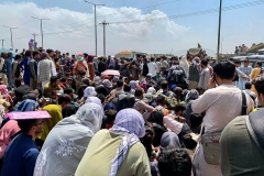 Afghan people wait to board a US military aircraft to leave the country at the airport in Kabul on August 20, 2021. (Photo by WAKIL KOHSAR/AFP via Getty Images)