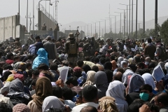 Afghans gather on a road near the airport in Kabul on August 20, 2021. (Photo by WAKIL KOHSAR/AFP via Getty Images)