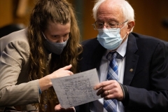 Sen. Bernie Sanders confers with a congressional staffer at a hearing in Washington. (Photo by GRAEME JENNINGS/POOL/AFP via Getty Images)