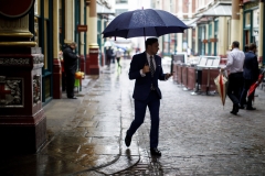 A businessman walks through the rain. (Photo credit: TOLGA AKMEN/AFP via Getty Images)