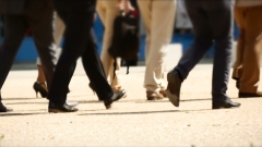 Businessmen walk to work. (Photo credit: YouTube/Transformation Video Library)