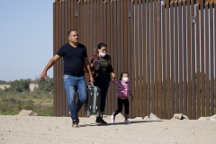 Migrants from Cuba walk along the border wall after crossing the United States and Mexico border, to turn themselves to authorities on May 13, 2021 in Yuma, Ariz. (Photo credit: RINGO CHIU/AFP via Getty Images)