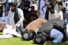 Taliban members pray in Kandahar at a gathering celebrating the U.S. troop withdrawal.  Photo by Javed Tanveer/AFP via Getty Images)