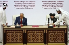U.S. envoy for Afghanistan Zalmay Khalilzad and Abdul Ghani Baradar of the Taliban sign the agreement in Doha in February 2020. (Photo by Karim Jaafar/AFP via Getty Images)