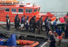 Illegal migrants plucked from a leaking inflatable boat in the Channel are escorted off a rescue vessel docked in Calais, northern France, last month. (Photo by Bernard Barron/AFP via Getty Images)