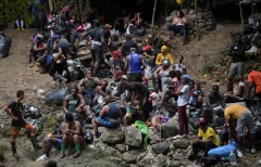 Haitian migrants rest as they cross the jungle of the Darien Gap, near Acandi, Choco department, Colombia, heading to Panama, on September 26, 2021, on their way trying to reach the US. - From Acandi, they started on foot -- and armed with machetes, lanterns and tents -- the dangerous trek of at least five days to Panama through the Darien jungle, battling snakes, steep ravines, swollen rivers, tropical downpours and criminals often linked to drug trafficking. (Photo by RAUL A