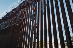 A man tries to scale the border wall attempting to cross in to the U.S. from Mexico at the border October 08, 2021 in San Luis, Arizona. (Photo by Nick Ut/Getty Images)