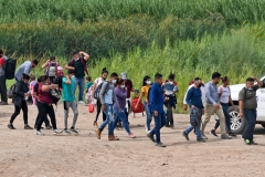 Migrants attempting to cross in to the U.S. from Mexico are detained by U.S. Customs and Border Protection at the border October 07, 2021 in San Luis, Arizona. (Photo by Nick Ut/Getty Images)