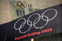 Tibetan and Uyghur activists hang a protest sign outside the Olympics Museum in Lausanne, Switzerland in June. (Photo by Fabrice Coffrini/AFP via Getty Images)