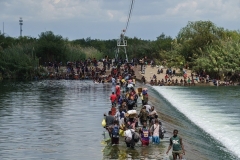 Migrants, many of them Haitian, cross the Rio Grande near Del Rio, Texas in September. (Photo by Paul Ratje/AFP via Getty Images)