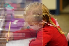 A kindergarten student does her work behind a mask and shield at Freedom Preparatory Academy on Sept. 10, 2020 in Provo, Utah. (Photo credit: GEORGE FREY/AFP via Getty Images)