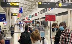 An airport employee checks the temperature of passengers before they are allowed to board their flight at Washington-Dulles International Airport on November 10, 2020, amid the Coronavirus pandemic. (Photo by DANIEL SLIM/AFP via Getty Images)