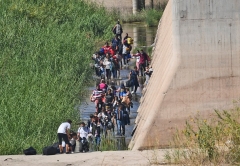 Migrants attempt to cross in to the U.S. from Mexico at the border October 10, 2021 in San Luis, Arizona. (Photo by Nick Ut/Getty Images)