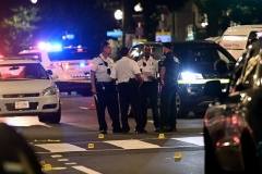 Police officers work at the scene of a shooting outside a restaurant in Washington, DC, on July 22, 2021.  (Photo by BRENDAN SMIALOWSKI/AFP via Getty Images)