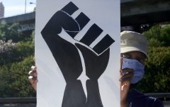 A protester holds a sign with a Black Lives Matter fist. (Photo credit: Horacio Villalobos/Corbis/Getty Images.jpg