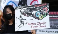 A protester holds up a sign during a rally in front of the Chinese Consulate in Los Angeles last week calling for a boycott of the Beijing 2022 Winter Olympics. (Photo by Frederic J. Brown/AFP via Getty Images)