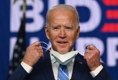 Joe Biden puts on a face mask. (Photo credit: JIM WATSON/AFP via Getty Images)
