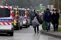 Migrants walk past police vehicles during the evacuation of the illegal migrant camp in Grande-Synthe, northern France, on Tuesday. (Photo by Denis Charlet/AFP via Getty Images)