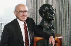 Nobel Prize-winning economist Milton Friedman poses with a sculpture of himself. (Photo credit: George Rose/Getty Images)