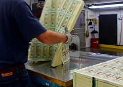 An employee stacks a pack of freshly printed sheets of 20 dollar bill representing a value of 200,000 at the US Treasury's Bureau of Engraving and Printing in Washington. (Photo by EVA HAMBACH/AFP via Getty Images)